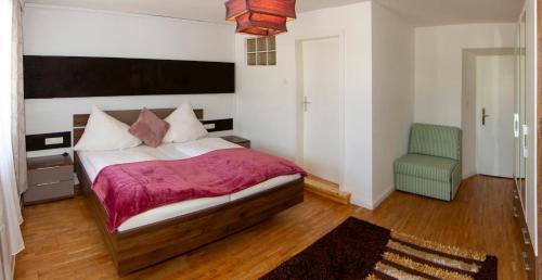 a bedroom with a large bed and a chair at Gasthof zur Post in Mieming