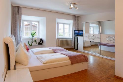 a bedroom with a large bed and a television at Gasthof zur Post in Mieming