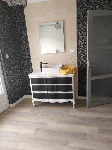 ein Bad mit einem Waschbecken und einem Spiegel in der Unterkunft Maison plume in Saint-Thiébault