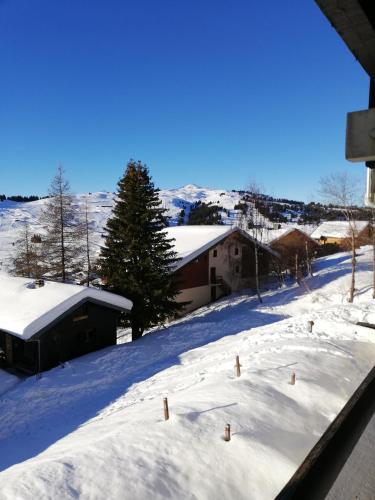 a view of a snow covered yard with buildings at les saisies ;loue a la semaine in Hauteluce