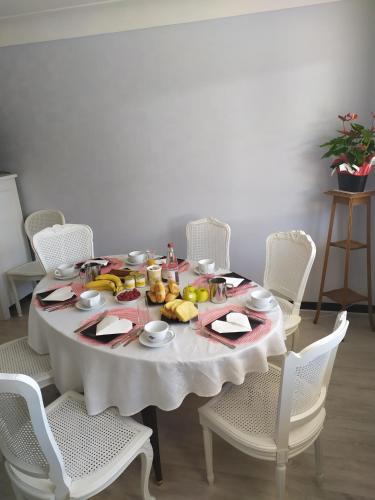 Ein weißer Tisch mit einem Haufen Obst drauf. in der Unterkunft Maison plume in Saint-Thiébault