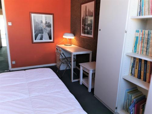 une chambre avec un lit et un bureau avec une lampe dans l'établissement Les Soleils, à Les Sables-dʼOlonne