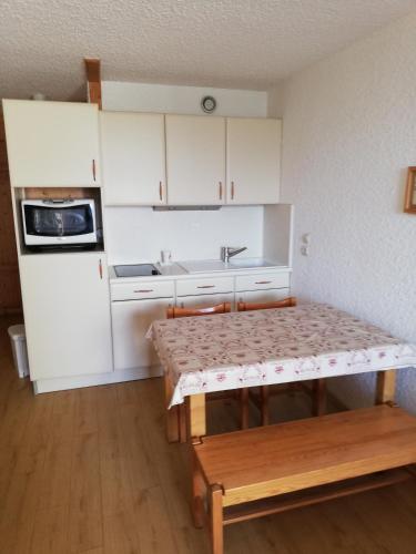 une petite cuisine avec une table et un évier dans l'établissement les saisies ;loue a la semaine, à Hauteluce