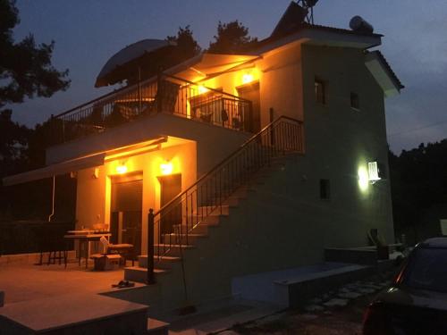 a building with a staircase leading up to it at night at EPavli Xenia Pefkochori-Paliouri 30m in Paliouri