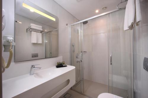 a bathroom with a glass shower and a sink at Suadhan Hotel in Istanbul