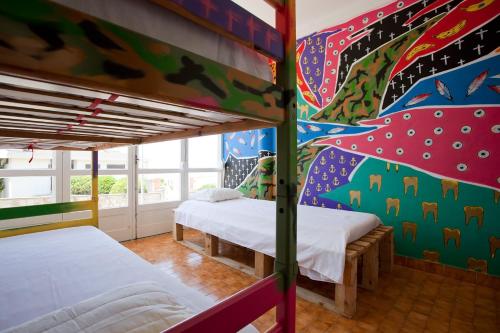 two bunk beds in a room with a colorful wall at Hostel & Surfcamp 55 in Ericeira