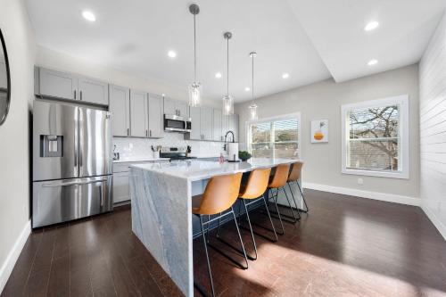 a kitchen with a large island with bar chairs at Family Friendly New Luxury Home Centrally located in Atlanta