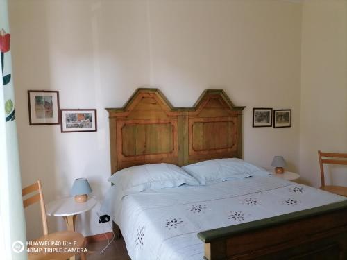 Schlafzimmer mit einem großen Bett mit einem Kopfteil aus Holz in der Unterkunft BeB Dorotina in Mozzo