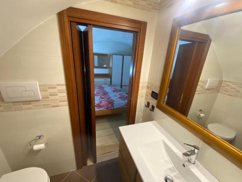 a bathroom with a sink and a mirror and a toilet at Casa Asia in Vieste