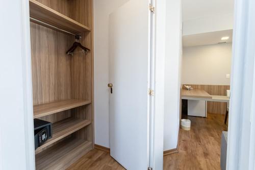a room with a closet with wooden shelves at H4 La Residence Paulista in Sao Paulo