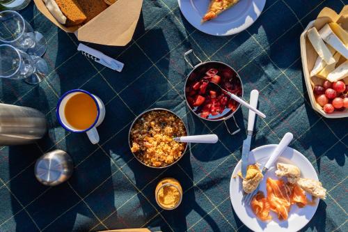 a blue table with plates of food and drinks at Barnett Hill Hotel in Guildford