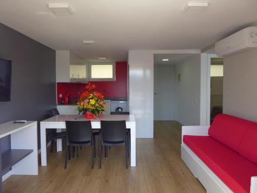 a kitchen and living room with a red couch and a table at Rentalmar Navarra family suites in Salou