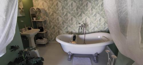 a bathroom with a bath tub and a sink at CasaBoutique cerca del mar con vistas a la montaña in Polop