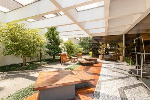 a courtyard with benches and tables in a building at H4 La Residence Paulista in Sao Paulo