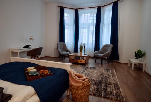 a living room with a bed and a tray of food at Zakarias Apartments in Miercurea-Ciuc