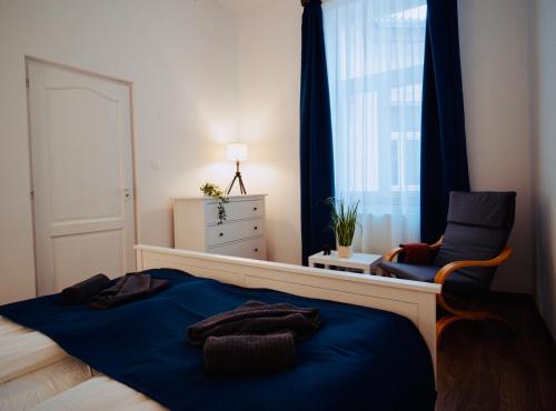 a bedroom with a bed and a chair and a window at Zakarias Apartments in Miercurea-Ciuc