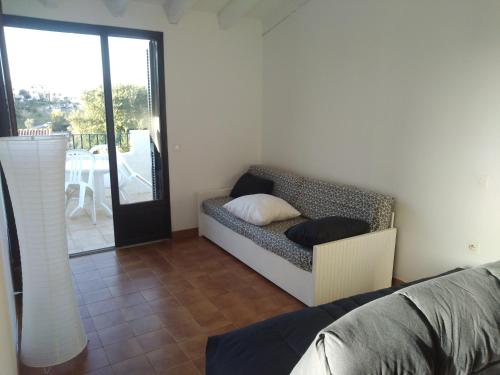 un soggiorno con divano e patio di Studio vue mer à Porticcio proche aéroport Ajaccio a Porticcio