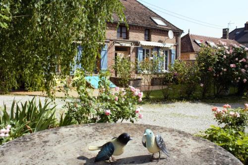 zwei Vögel, die auf einem Tisch im Hof sitzen in der Unterkunft Gîtes Famille En Othe in Bouilly