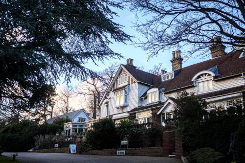 a large white house with a roof at Rowhill Grange Hotel & Utopia Spa in Dartford