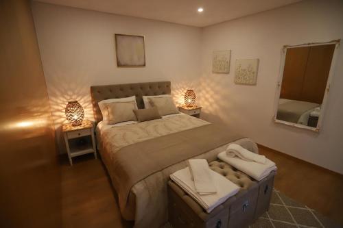 - une chambre avec un lit, deux lampes et un miroir dans l'établissement Casa Martaínha, à Sernancelhe