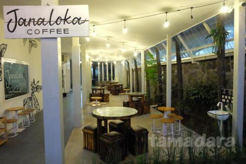a coffee shop with a table and some chairs at Tamadara Guesthouse Jogja in Seturan