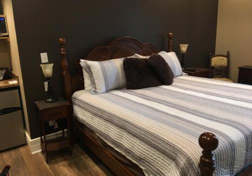 a bedroom with a large bed with a wooden headboard at Historic Kahn Hotel in Jefferson