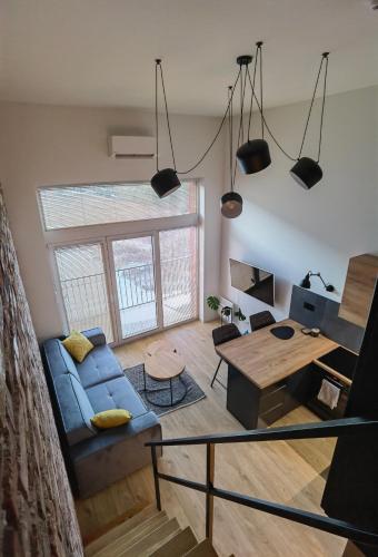 een woonkamer met een blauwe bank en een tafel bij Apartament Loft Studio Airport blisko lotniska Zarembowicza lotnisko in Wrocław