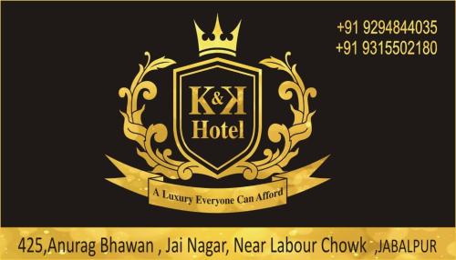 a gold and black logo with a crown and a ribbon at K & K Hotel in Jabalpur