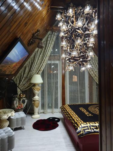a bedroom with a bed and a chandelier at Camere LUX Telecabina Busteni in Buşteni