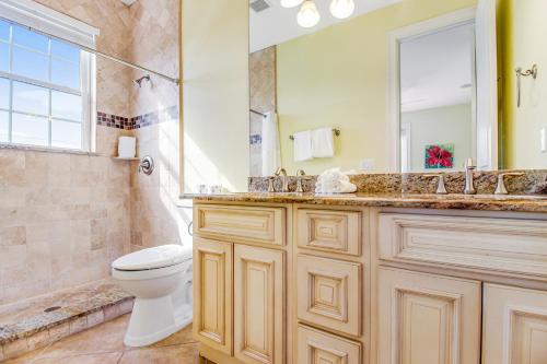 een badkamer met een toilet, een wastafel en een spiegel bij Almost Gulf Front in Holmes Beach