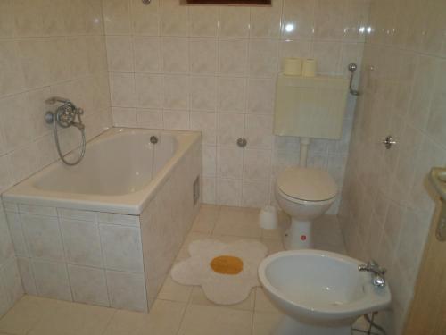 a bathroom with a tub and a toilet and a sink at Apartment Nella in Molat