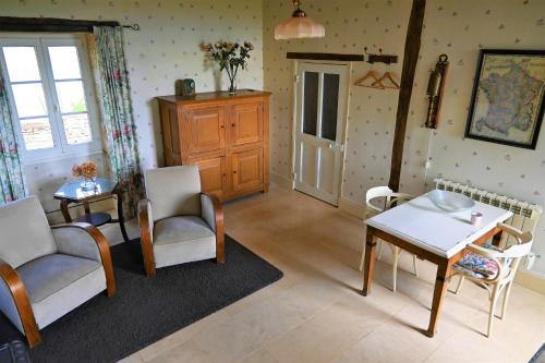 a living room with a table and two chairs and a table and a tablektop at Maison Machecourt in Champallement