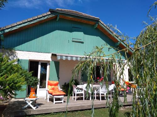 una casa verde con sillas y una mesa en un porche en Greselin en Chorges