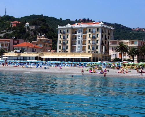 a group of people on a beach with buildings at Lido Resort in Finale Ligure