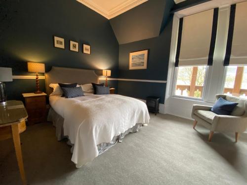 a bedroom with a bed and a chair at Knockderry Country House Hotel in Cove