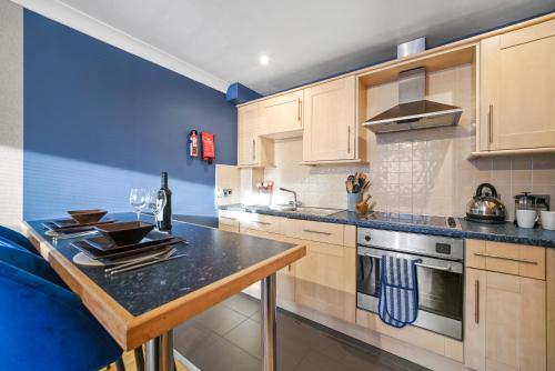 eine Küche mit Holzschränken und einer Arbeitsplatte in der Unterkunft Modern Warwick Apartment, Sleeps 3, Claverdon House in Warwick