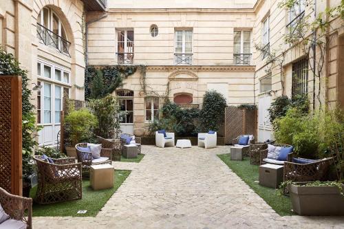 ボルドーにあるL'Hôtel Particulier Bordeauxの青い枕と椅子が備わる建物の中庭