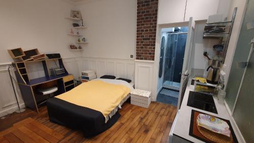 une chambre avec un lit et un bureau et une cuisine dans l'établissement Studio 16m2 dans immeuble Hausmannien, à Paris
