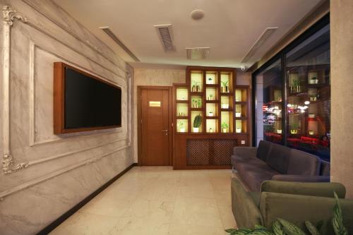 a living room with a couch and a television on a wall at Suadhan Hotel in Istanbul