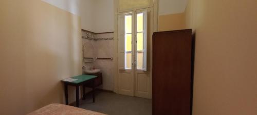 a small bathroom with a door and a window at Hotel Mallorca in Mendoza