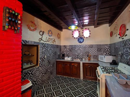 cocina con azulejos blancos y negros en las paredes en Casa Vieja, en Mazamitla
