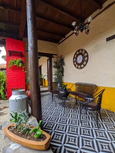 a patio with chairs and a table and a clock at Casa Vieja in Mazamitla