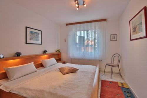 a bedroom with a large bed and a chair at Strandschlößchen Strandschlösschen Appartement 3 in Haffkrug