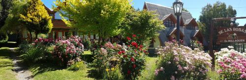 a garden of flowers in front of a building at De las Rosas Bariloche in San Carlos de Bariloche