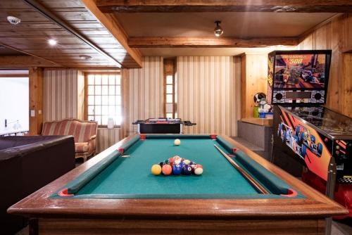 a billiard room with a pool table and a machine at Hôtel du Glacier in Champex