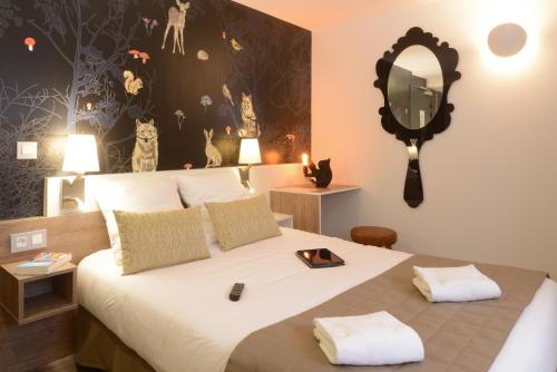 1 dormitorio con 1 cama grande y espejo en la pared en Hotel Arc-En-Ciel Colmar Contact Hotel, en Colmar