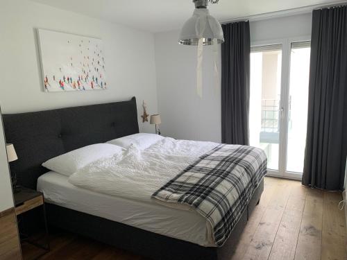 ein Schlafzimmer mit einem Bett und einem großen Fenster in der Unterkunft Apartment Bellania in Davos