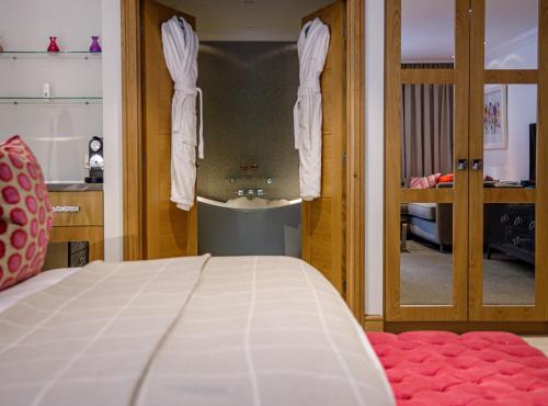 een slaapkamer met een bed en een badkamer met een spiegel bij Alexander House Hotel & Utopia Spa in Turners Hill