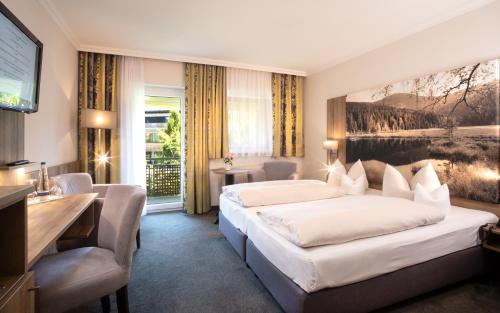 アルラッハにあるHotel Herzog Heinrichのベッド2台とテレビが備わるホテルルームです。