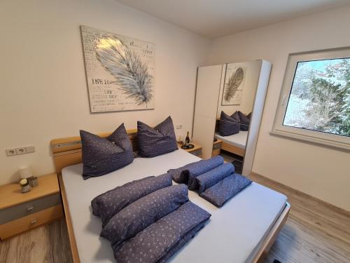 ein Schlafzimmer mit einem Bett mit blauen Kissen darauf in der Unterkunft Apart Bubendorfer in Lermoos